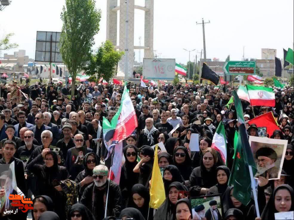 توزیع پوستر‌های آقای شهید ایران در مسیر پیاده روی بازماندگان تشییع در اردبیل+ عکس