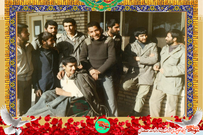 نفر نشسته بر روی ویلچر شهید حسینعلی مونسان پس از مجروحیت در عملیات محرم